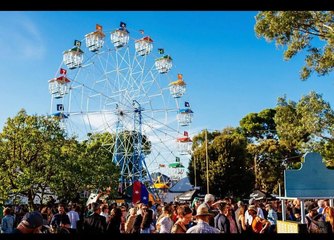 Ferris wheel at outdoor festival with crowds